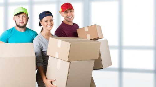 Local removal helper carrying boxes near a North London property