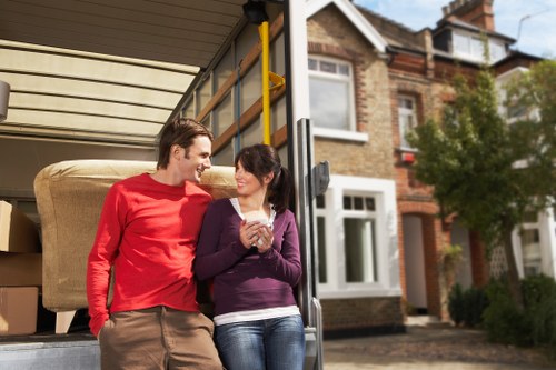 Professional movers carrying furniture through a North London property